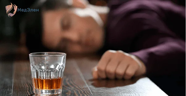 Мужчина в алкогольном опьянении лежит на столе